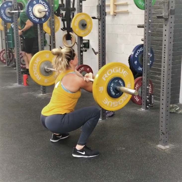 woman doing front squat in gym