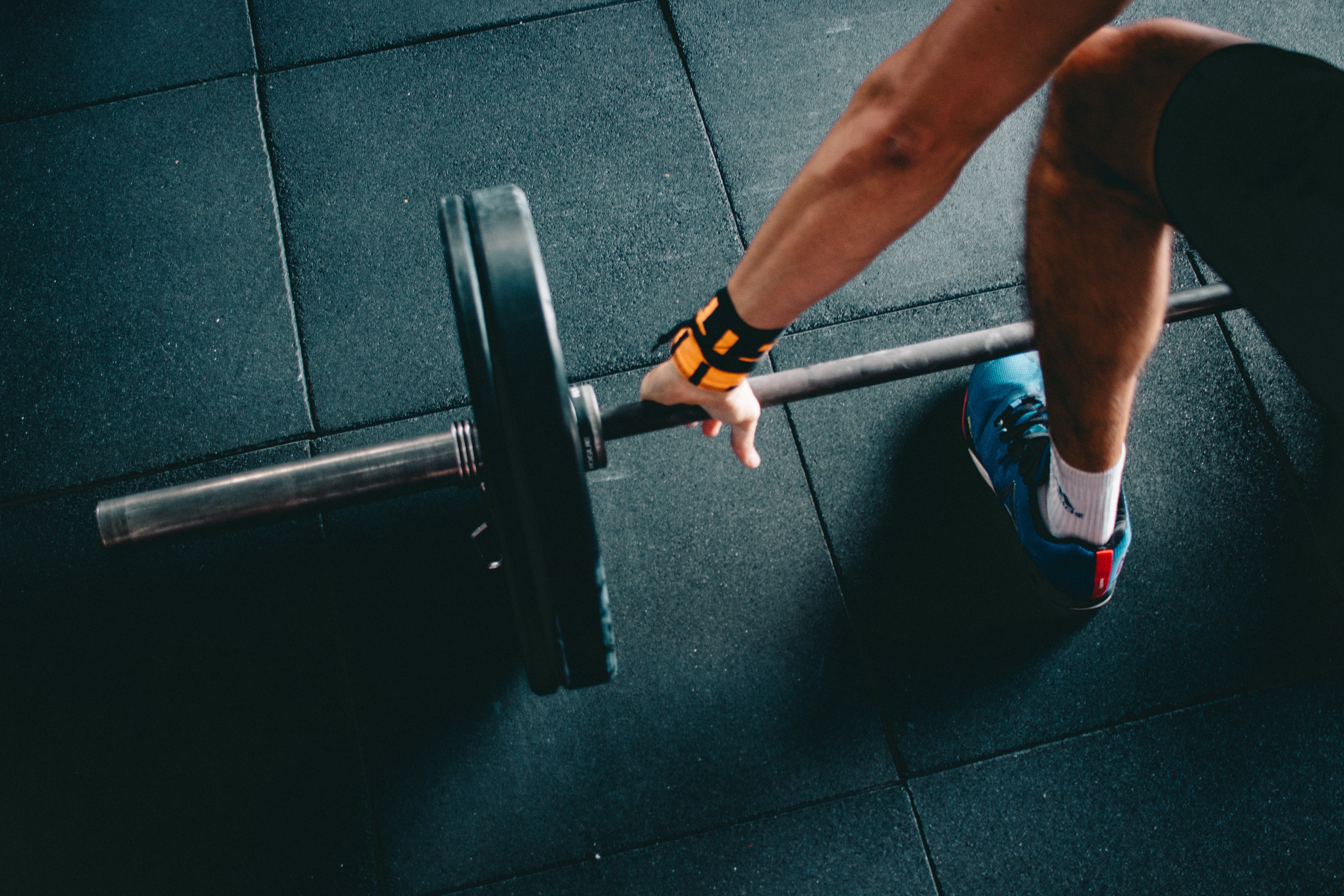 man lifting barbell with weight